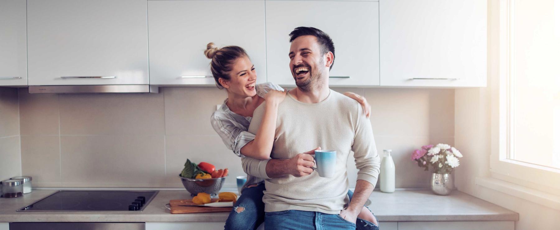 Happy couple in new kitchen and home